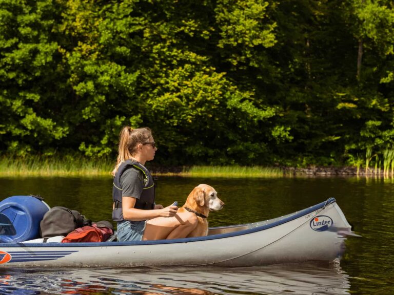 vrouw met hond en kind in een kano in Zweden